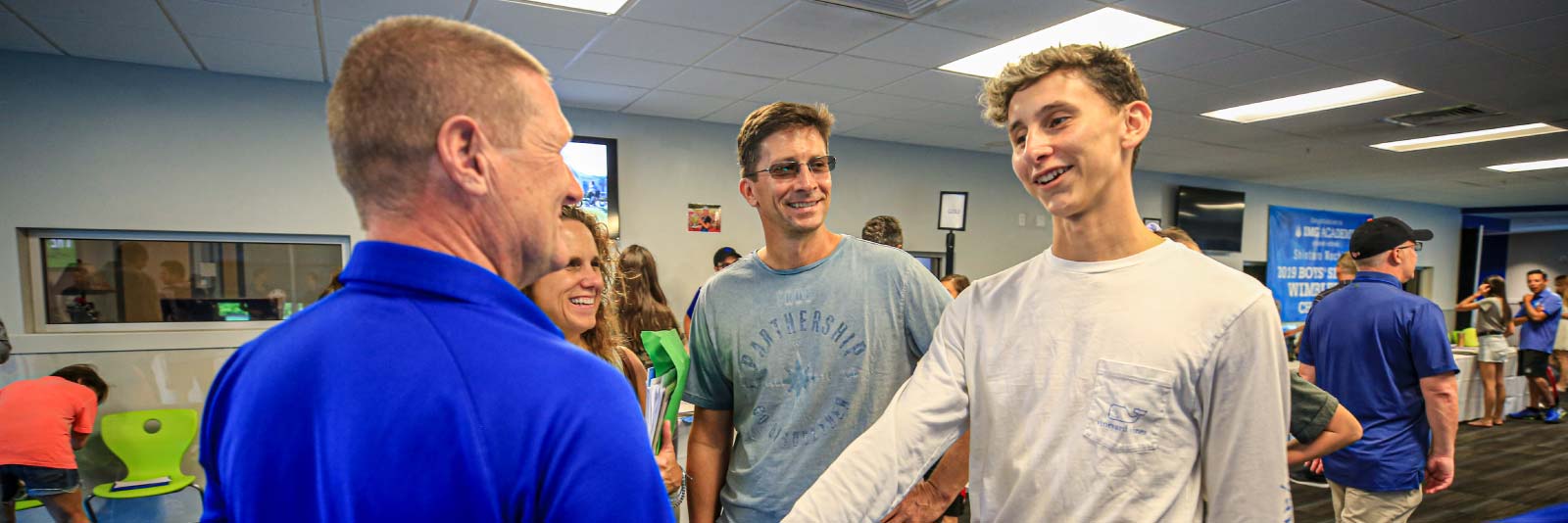 athlete and parents talking with a college coach